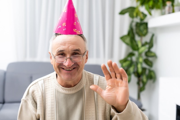 Un anciano con un gorro de fiesta en la cabeza.