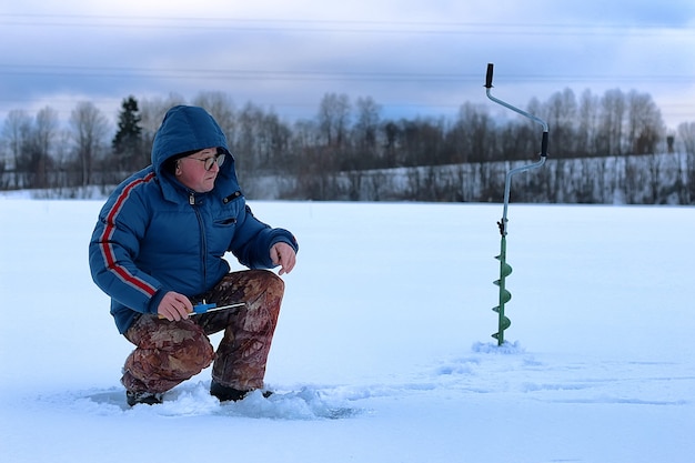 Anciano ha estado pescando en el invierno en el lago