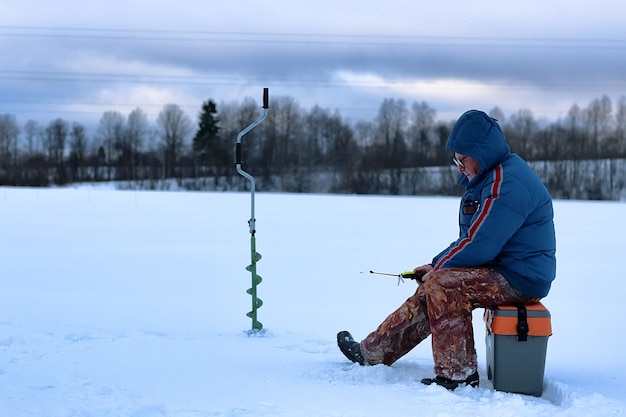 Anciano ha estado pescando en el invierno en el lago