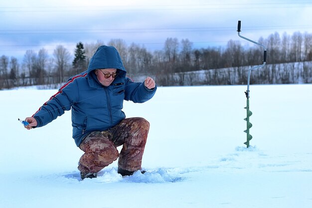 anciano ha estado pescando en el invierno en el lago