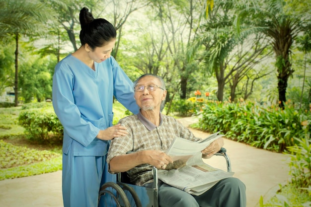 Un anciano habla con su enfermera en el parque