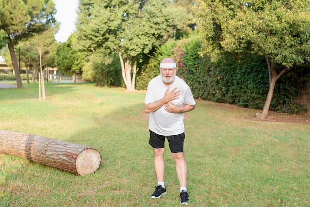 Foto un anciano haciendo ejercicio al aire libre con problemas cardiovasculares y dolor en el pecho