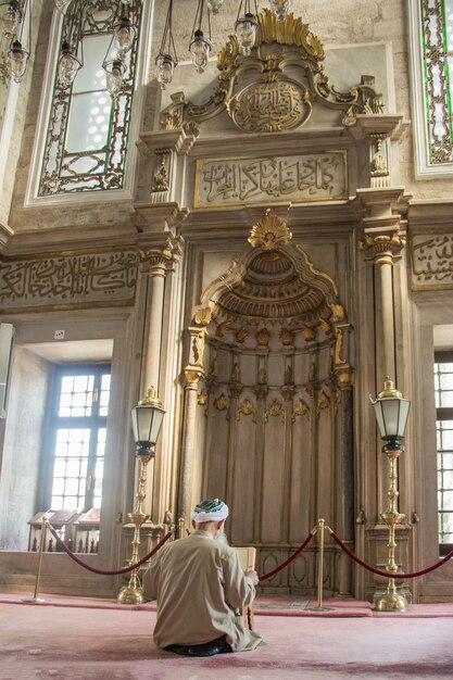 Anciano leyendo Corán en una mezquita