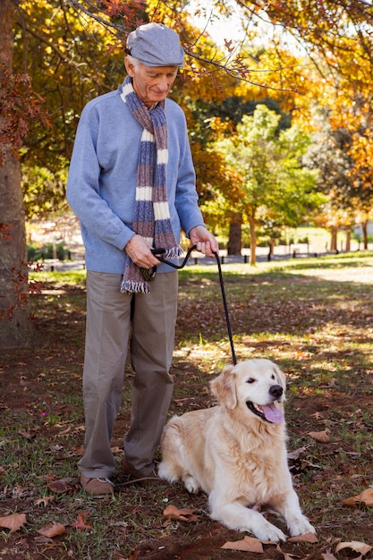 Anciano manteniendo a su perro en una pista