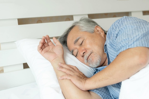 Foto anciano masculino mayor durmiendo en la cama en el estilo de vida matutino concepto masculino mayor