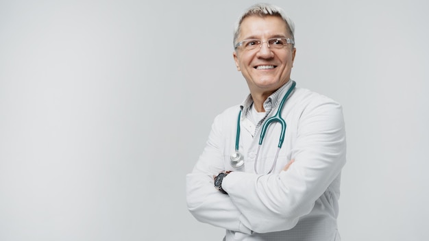 Foto un anciano médico con anteojos muestra una sonrisa en uniforme