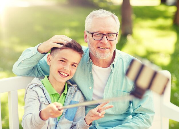 Foto un anciano y un niño tomando selfies con su teléfono inteligente