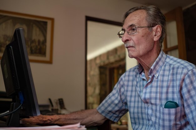 Anciano con ordenador portátil. Hombre mayor con tecnología.