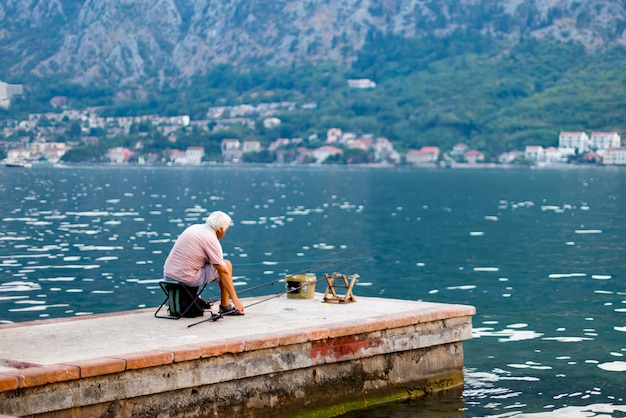 El anciano pesca en el mar