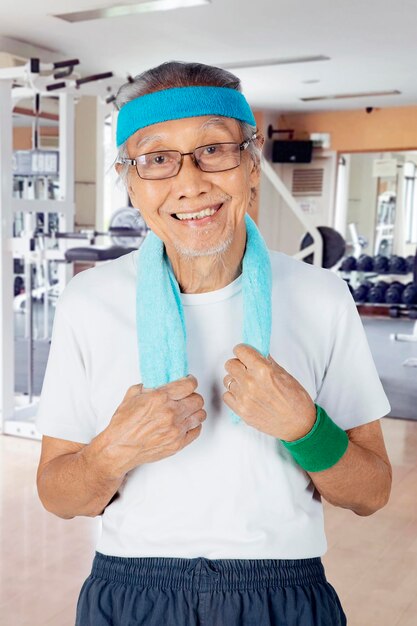 Anciano de pie en el gimnasio