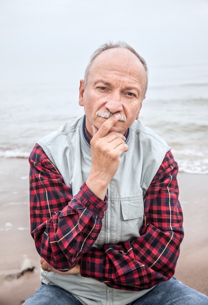 Anciano en la playa en un día brumoso