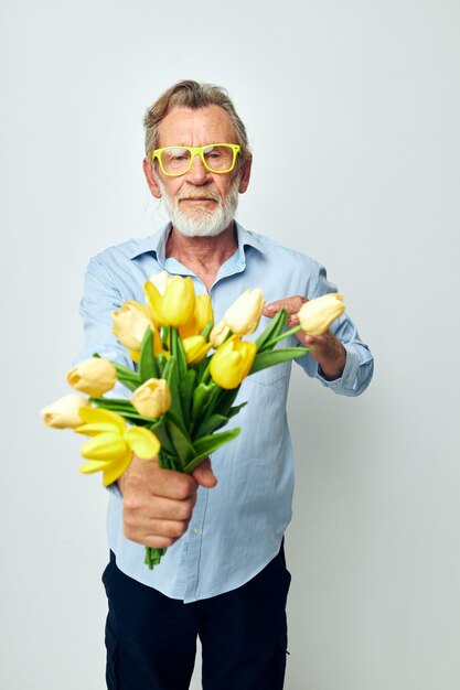 Anciano un ramo de flores con gafas como regalo fondo claro