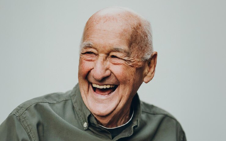 Foto el anciano sonríe y se ríe felizmente con fondo blanco