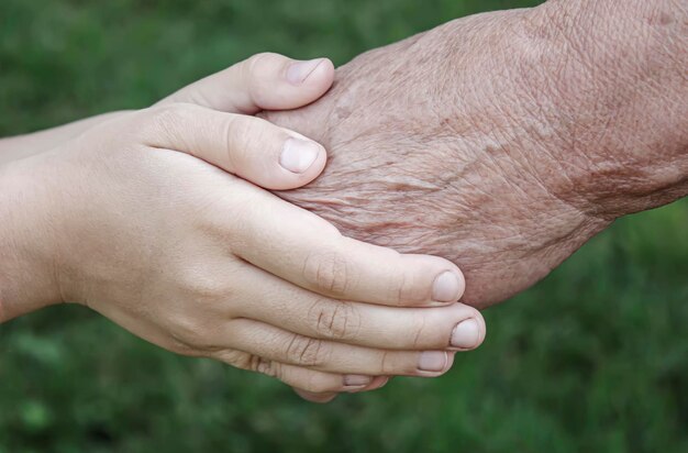 Anciano sosteniendo las manos de los niños personas de enfoque selectivo