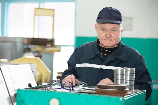 Un anciano trabaja en un torno Torneado