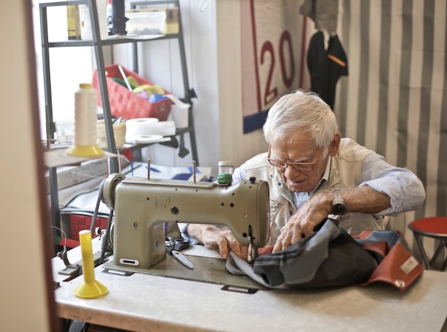 Anciano trabajando en una máquina de coser