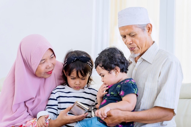 Ancianos padres musulmanes lamiendo a sus nietos