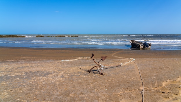 Âncora e barco de pesca à beira-mar