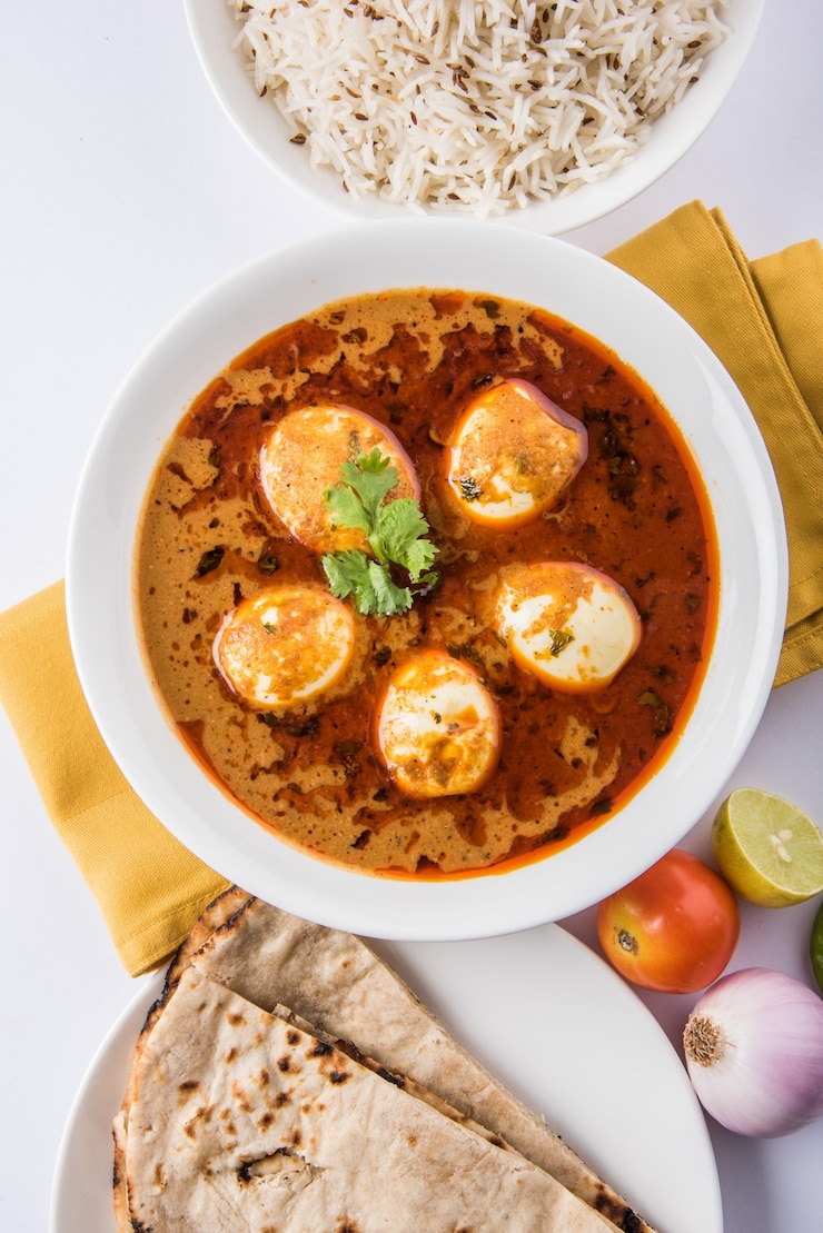 Foto anda curry oder egg masala soße, indisches scharfes essen oder rezept, serviert mit jeera reis, roti oder naan, selektiver fokus. über bunter oder hölzerner tischplatte