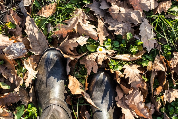 Andando em botas de couro pelo parque da cidade no outono