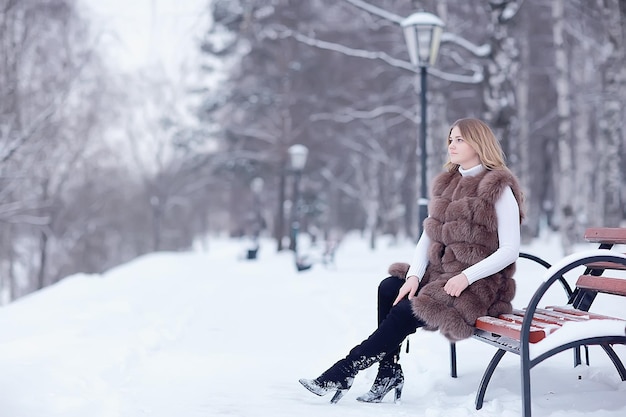 andar em uma garota de natal de parque de inverno/bela modelo posando na estação de inverno andar no parque da cidade