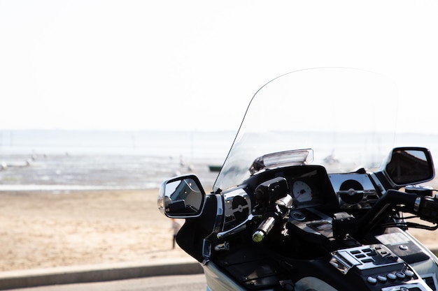 Foto ande de bicicleta na motocicleta oceânica perto da costa na bela praia costeira