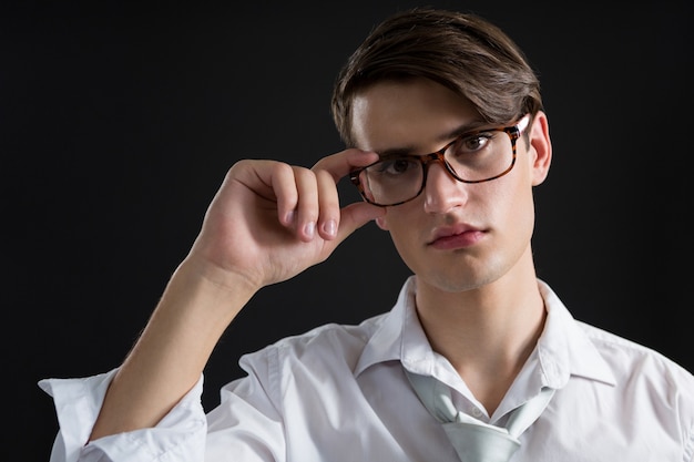 Androgyner Mann, der in der Brille aufwirft