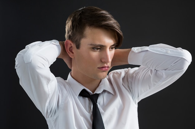 Androgyner Mann mit den Händen am Hals