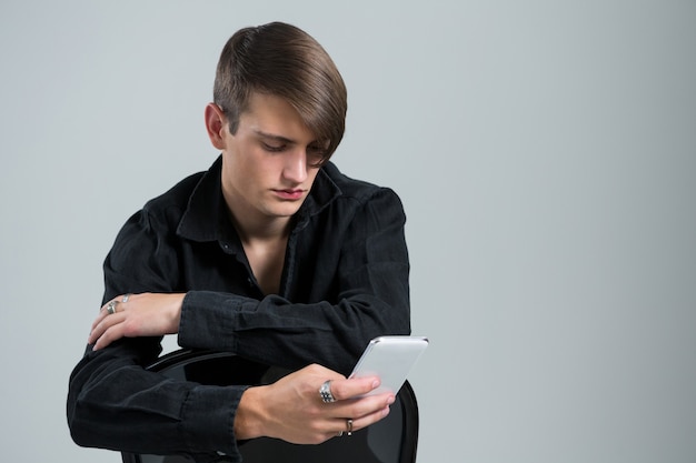 Androgyner Mann mit Handy