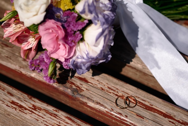 Foto anéis de casamento e buquê no fundo