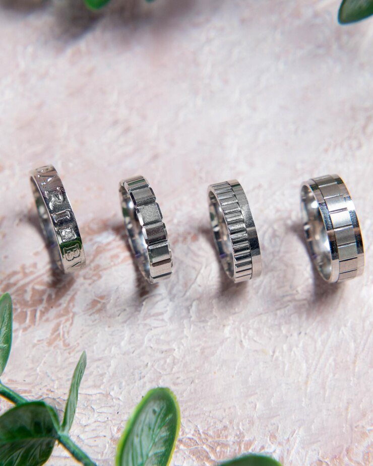 Foto anéis de casamento exibidos em superfície texturizada com vegetação