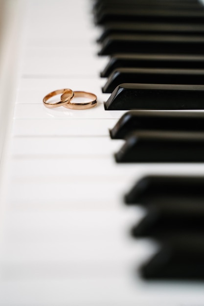 Anéis de casamento nas teclas do piano anéis de casamento dourados estão no espaço livre do piano para texto