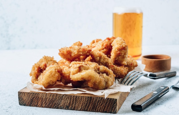 Anéis de lula à milanesa com limão em um fundo branco Lanche para cerveja