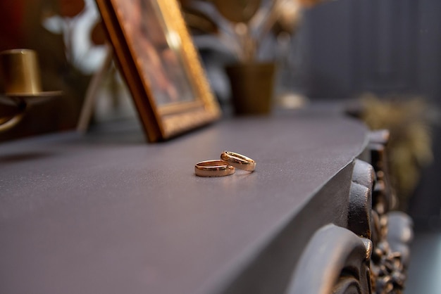 Anéis de ouro de casamento na prateleira da manhã dos noivos