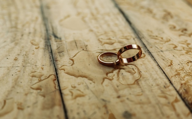 Anéis de ouro em uma parede de madeira Conceito de casamento.