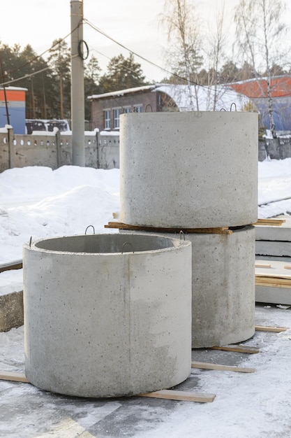 Anéis de poços de concreto armado no armazém da fábrica de produtos de concreto no inverno