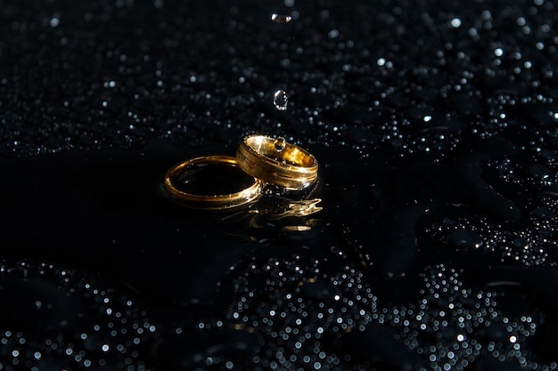 Anéis em um fundo escuro Anéis de casamento Jóias