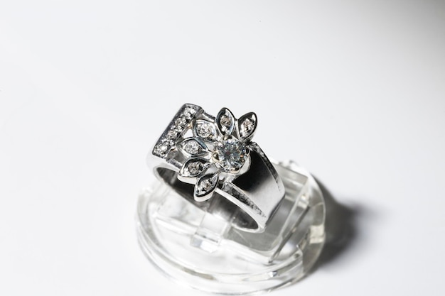 Anel de diamante de ouro branco em um tema floral de fundo branco na borda