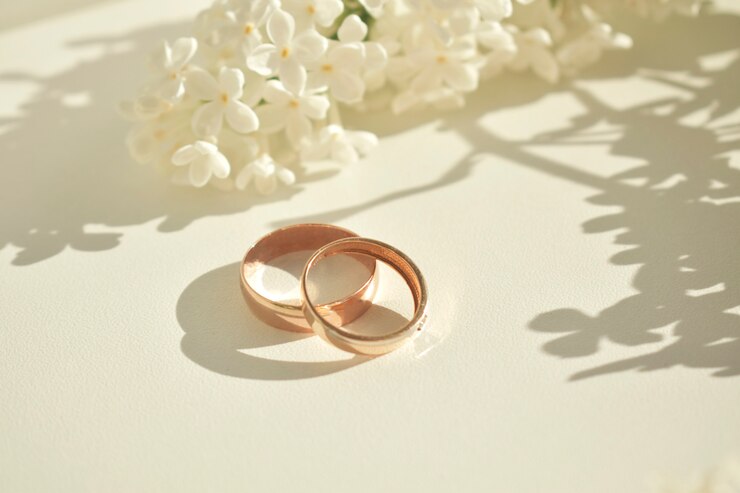 Anel de noivado. Sobre um fundo branco e com delicadas flores brancas. Símbolos e atributos do casamento