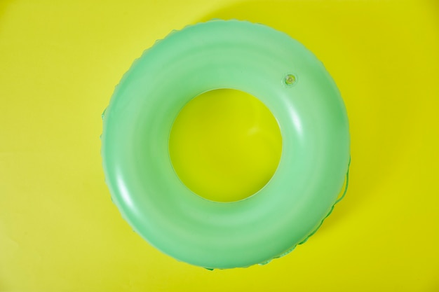 Anel inflável verde sobre fundo amarelo