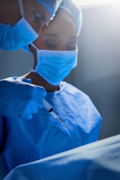 Foto anestesiando o paciente foto de um grupo de cirurgiões trabalhando em um paciente em uma sala de cirurgia