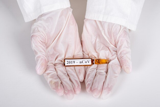 En anfibios con guantes blancos de un trabajador médico se encuentra una ampolla