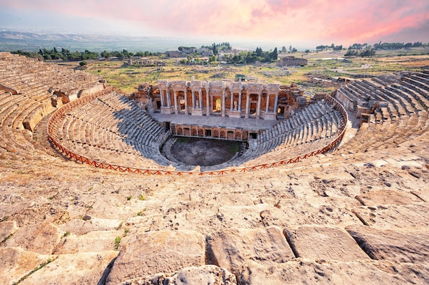 Foto anfiteatro na antiga cidade de hierápolis sob céu rosa dramático