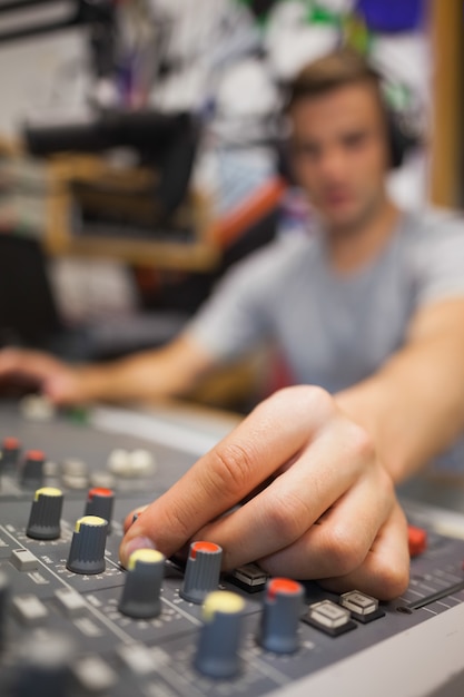 Foto anfitrião de rádio bonito moderando o volume voltado