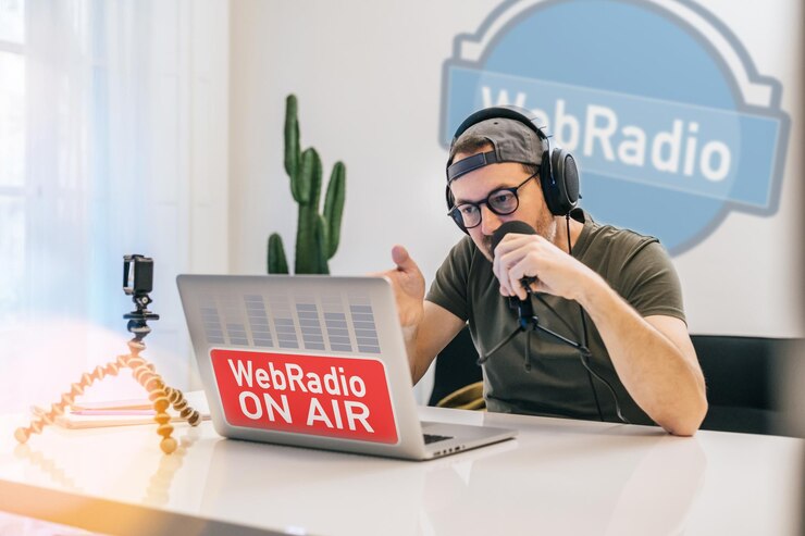 Foto anfitrião de rádio em fones de ouvido transmite ao vivo em estúdio homem transmitindo áudio usando microfone e laptop