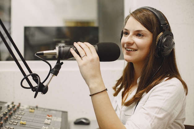Anfitrión femenino comunicándose por el micrófono. Mujer en estudio de radio.