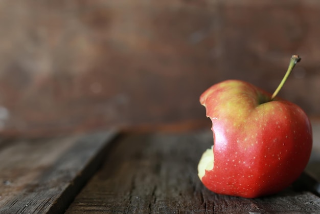 Angebissener Apfel auf einem hölzernen Hintergrund