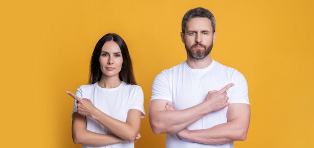 Angebot von Millennial-Paar Freund und Freundin zeigen Finger Paar von Mann und Frau isoliert auf gelb Familienpaar zeigt Finger Millennial Mann und Frau machen Angebot