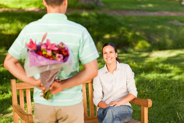 Angebotblumen des jungen Mannes seiner Frau