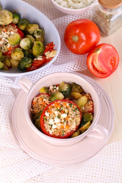 Angefüllte Tomaten in der Pfanne und in der Schüssel auf Holztischnahaufnahme Beschneidungspfad eingeschlossen